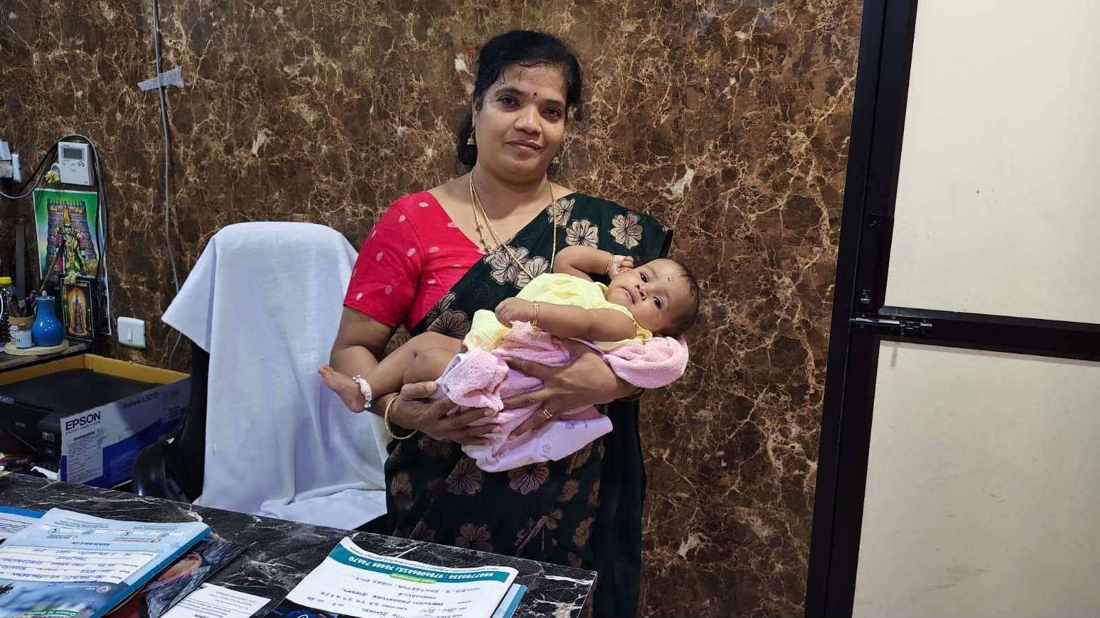 Dr. Sangeetha Balamurugan holding a baby in her consultation room
